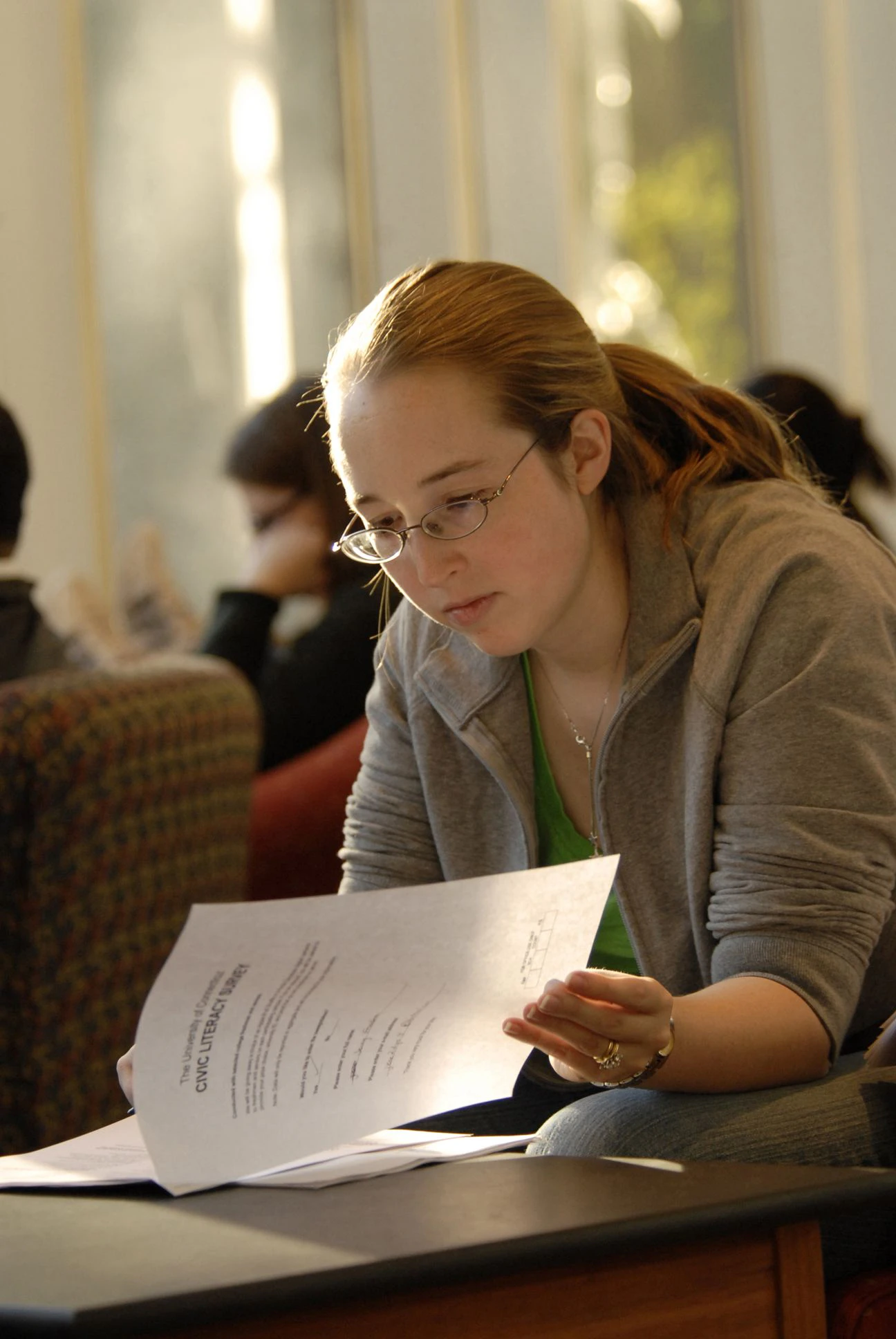 Penn student reading a packet of papers very closely