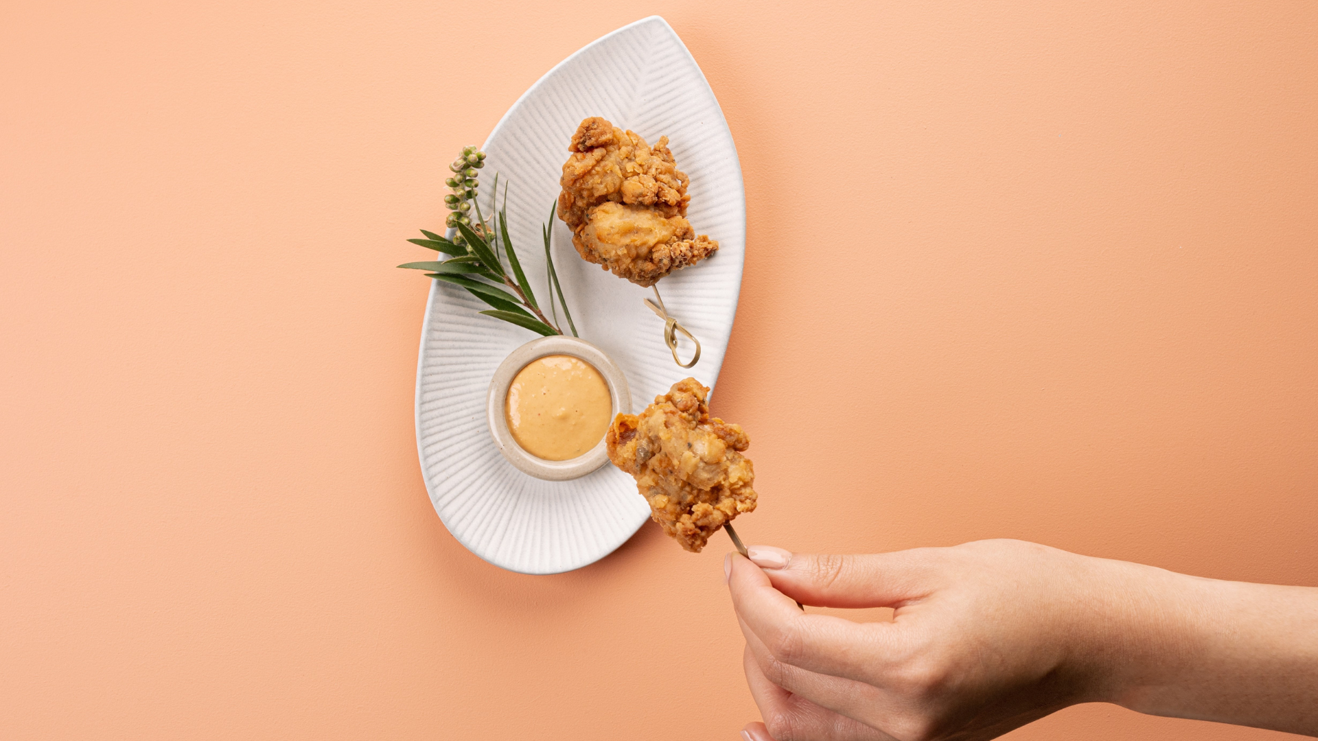 Close up of hand taking food from plate.